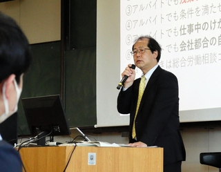兵庫県立大の学生に向けて労働時間や就業規則について講義する兵庫労働局の赤松俊彦局長＝神戸市西区学園西町８