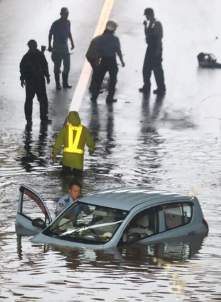 冠水したアンダーパスで立ち往生した乗用車。運転手は救出された＝８日午後３時５１分、三田市川除