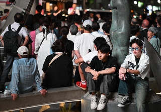 街頭演説のそばで座り込む若者。次世代にどのような社会をつなぐか、選挙の１票の重みは大きい＝神戸市中央区加納町４、サンキタ広場