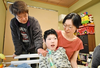 息子の鎧さん（中央）を見詰める兼田かおりさん（右）と潤一郎さん＝神戸市須磨区