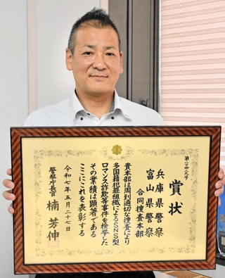 警察庁長官賞の賞状を持つ兵庫県警国際捜査課の神野潤警部＝県警本部