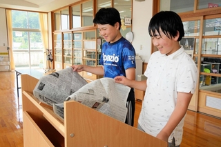 新聞閲覧台で新聞を読む児童ら＝養父市八鹿町宿南