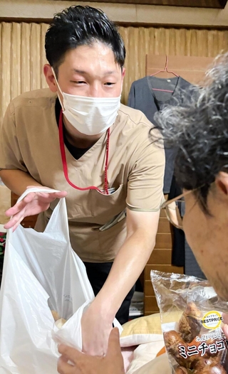次の利用日までの食料品を買って届ける池田知樹さん。１人暮らしの男性にとって訪問介護は生命線だ＝兵庫県猪名川町内