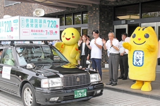 アナウンサーのいがらしあみさん（はばタンの右）とワタナベフラワーのムサさん（同２人目）らに見送られながら出発する参院選の自動車啓発＝兵庫県庁
