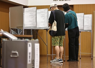 記載台で比例代表の投票先を書き入れる有権者＝２０日午前、神戸市中央区山本通１（撮影・長嶺麻子）