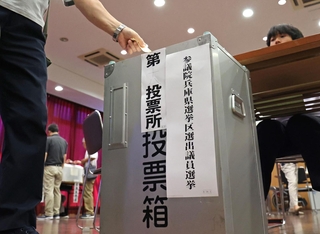選挙区の投票用紙を投票箱に入れていく有権者＝２０日午前、神戸市中央区山本通１（撮影・長嶺麻子）