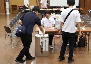 選挙区の投票用紙を投票箱に入れていく有権者＝２０日午前、神戸市中央区山本通１（撮影・長嶺麻子）