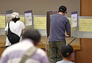 記載台で参院選兵庫選挙区の投票先を書き入れる有権者ら＝２０日午前、神戸市中央区山本通１（撮影・長嶺麻子）