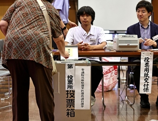 選挙区の投票用紙を投票箱に入れていく有権者＝２０日午前、神戸市中央区山本通１（撮影・長嶺麻子）