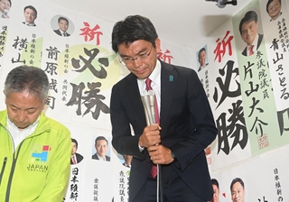 支援者らに頭を下げる吉平敏孝氏＝21日未明、神戸市中央区元町通２（撮影・風斗雅博）