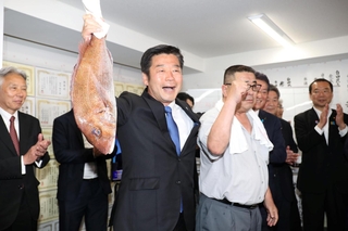 支援者から贈られたタイを手に喜ぶ加田裕之氏＝２１日未明、神戸市中央区加納町２（撮影・辰巳直之）