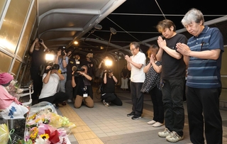 慰霊碑「想の像」の前で手を合わす遺族＝２１日夜、明石市大蔵海岸通１（撮影・丸山桃奈）