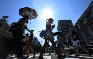 強い日差しが降り注ぎ、日傘を差す人や冷たい飲み物を飲む人の姿も＝２９日午後、神戸市中央区海岸通１（撮影・笠原次郎）