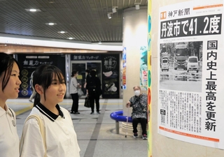 最高気温の観測史上１位の更新を伝える神戸新聞の張り出し号外＝30日午後、神戸市中央区、デュオこうべ