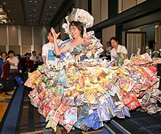 新聞紙で作ったドレスを着て登場する西沢みゆきさん＝３１日午後、神戸市中央区港島中町６、神戸ポートピアホテル（撮影・斎藤雅志）
