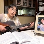 夫澄彦さんの写真を前にアスベストを題材にした歌を歌う平地千鶴子さん。生前は一緒に音楽を楽しんだという＝尼崎市