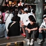 街頭演説のそばで座り込む若者。次世代にどのような社会をつなぐか、選挙の１票の重みは大きい＝神戸市中央区加納町４、サンキタ広場