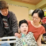 息子の鎧さん（中央）を見詰める兼田かおりさん（右）と潤一郎さん＝神戸市須磨区