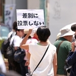 選挙戦は終盤に。自らの決意を込めて紙を掲げる女性＝神戸市中央区