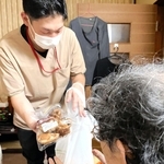 買い物代行の商品を確認する男性（手前）。最寄りのスーパーまでは片道２５分ほどかかる＝兵庫県猪名川町