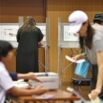 選挙区の投票を済ませた後に、記載台で比例代表の投票先を書き入れる有権者ら＝２０日午前、神戸市中央区山本通１（撮影・長嶺麻子）