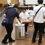 選挙区の投票用紙を投票箱に入れていく有権者＝２０日午前、神戸市中央区山本通１（撮影・長嶺麻子）