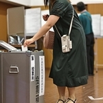 比例代表の投票用紙を投票箱に入れていく有権者＝２０日午前、神戸市中央区山本通１（撮影・長嶺麻子）