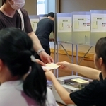 投票用紙を受け取り、記載台で参院選兵庫選挙区の投票先を書き入れる有権者ら＝２０日午前、神戸市中央区山本通１（撮影・長嶺麻子）