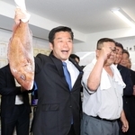支援者から贈られたタイを手に喜ぶ加田裕之氏＝２１日未明、神戸市中央区加納町２（撮影・辰巳直之）