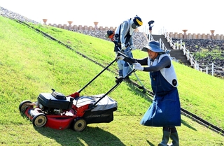 炎天下で古墳の除草作業をするＮＰＯ法人「輝かすみが丘」のメンバー＝神戸市垂水区五色山４