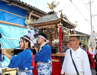 能登半島地震で被災した町を巡行するみこしと福田喜次さん（右）＝１７日午後、石川県輪島市門前町黒島町