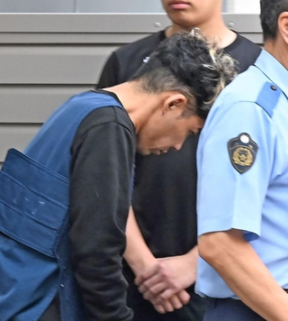 捜査員に連れられて警察車両に乗り込む谷本将志容疑者＝２４日午前９時２３分、神戸市中央区吾妻通５