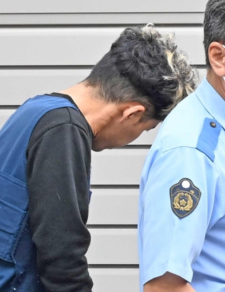 警察車両に歩いて向かう谷本将志容疑者＝２４日午前、葺合署