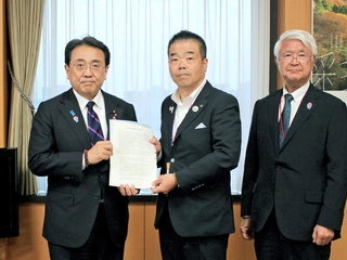 防災庁の関西設置を求める要望書を赤沢亮正設置準備担当相（左）に手渡す関西広域連合長の三日月大造滋賀県知事（中央）ら＝東京都内