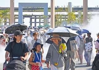 厳しい日差しが照りつける万博会場で、ミストを浴びる来場者たち＝３１日午後、大阪市此花区の夢洲（撮影・大田将之）
