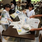 会場で新聞を手に取り、興味がある記事を探す児童たち＝１日午前、神戸市東灘区岡本８、甲南大学岡本キャンパス（撮影・笠原次郎）