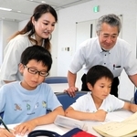 感想文を書く児童を見守る米山正幸さん（後列右）と未来さん（同左）＝神戸市中央区東川崎町１、神戸新聞社