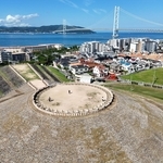 古墳そばの住宅街の奥に淡路島や明石海峡大橋が見え、絶景が広がる＝神戸市垂水区五色山４（ドローンで撮影）