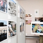 カメラマンたちが撮影した能登の写真が並ぶ京都展会場で、避難所で再会した祖母の写真を手にする頼光和弘さん＝京都府亀岡市余部町宝久保