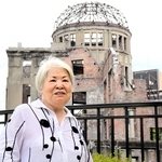 原爆ドームを背に平和への思いを語る田中洋子さん＝６日午前、広島市中区