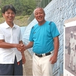 父馨さんらの顕彰碑の前で、東洋大姫路の岡田龍生監督（右）を激励する野球部ＯＢ会長の梅谷真吾さん＝姫路市打越の同校グラウンド（撮影・辰巳直之）