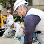 背中に２カ所のファンを取り付けた空調ベストを着て、作業する神戸市建設局中部建設事務所の職員。中に保冷剤を入れるポケットもあり、より冷気を感じながら仕事に集中できるという＝神戸市中央区三宮町１