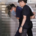 捜査員に付き添われ、葺合署に入る谷本将志容疑者＝２２日午後１１時４２分、神戸市中央区吾妻通５