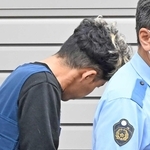 警察車両に歩いて向かう谷本将志容疑者＝２４日午前、葺合署
