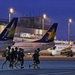 まだ夜の明けきらない中、駐機する飛行機の前を走り抜けるランナーたち＝３０日朝、神戸市中央区、神戸空港