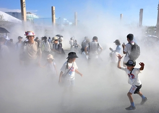 厳しい日差しが照りつける中、ミストを浴びながら元気に駆け回る子どもら＝３１日午後、大阪市此花区の夢洲（撮影・大田将之）