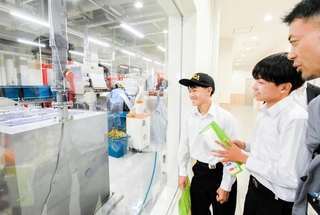 バイオマス発電などに取り組む企業の工場を見学する浜脇中学校の生徒＝岡山県真庭市勝山（提供）