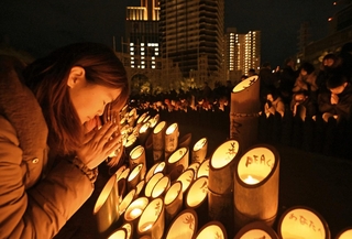 阪神・淡路大震災の発生時刻に黙とうする人たち＝２０２５年１月１７日、神戸・三宮の東遊園地