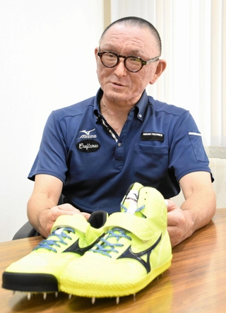 陸上の世界選手権東京大会用にデザインされたスパイクを前に話す亀井晶さん＝＝宍粟市山崎町千本屋、ミズノテクニクス山崎ランパード工場