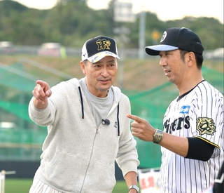 藤川球児監督と談笑する渡辺謙さん（左）＝２月、沖縄・宜野座
